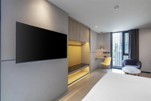 a bedroom with a flat screen tv on a wall at Best Western Ratchada Hotel in Bangkok