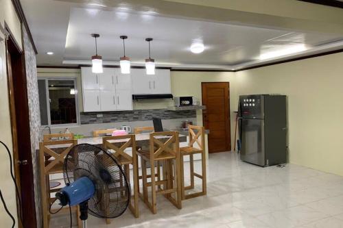 a kitchen with a table and a refrigerator at Michael's Homestay - Farm Villa near Patar Beach & Bolinao Falls in Bolinao