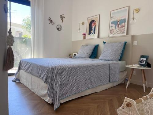 ein Schlafzimmer mit einem Bett mit einer blau-weißen Bettdecke in der Unterkunft Superbe villa avec piscine in Castelnau-le-Lez