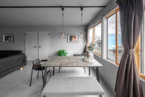 a dining room with a table and a window at WhiteGarden YIG STAY in Furano