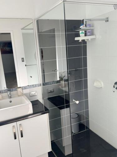 a bathroom with a sink and a glass shower at The Lux Dip in Perth