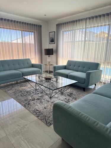 a living room with blue couches and a table at The Lux Dip in Perth