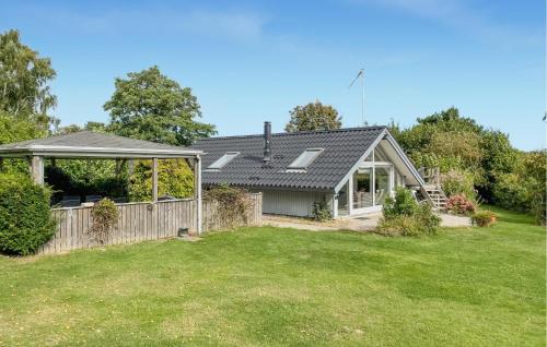 a house with a fence and a yard at Awesome Home In Tranekær With Wifi in Tranekær