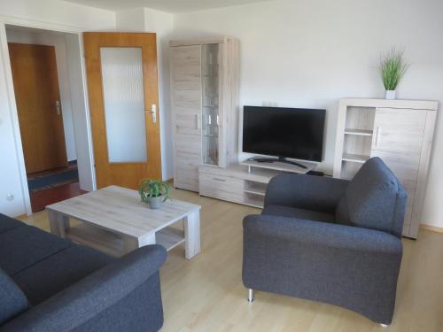 a living room with two chairs and a television at Ferienwohnung Stadtblick in Bräunlingen