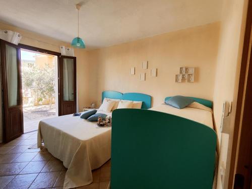 una camera da letto con due letti e una parete verde di Casa Lisa Agorà mare e relax a Villasimius