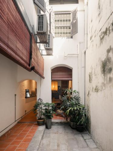 an alley with potted plants in a building at Cheong Fatt Tze - The Blue Mansion in George Town