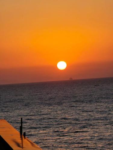 a sunset over the ocean with the sun setting at Résidence touristique les jasmins الياسمين in Les Sablettes Mazagran-Plage