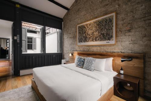a bedroom with a bed and a brick wall at Cheong Fatt Tze - The Blue Mansion in George Town