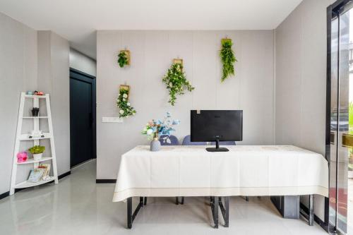 a white table with a computer on it in a room at Qiyunju Hotel-24H Free Airport Pickup Drop-off in Shanghai