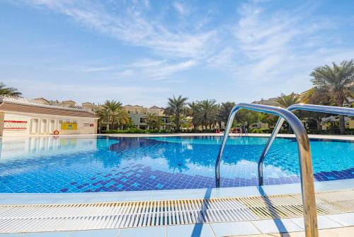 una piscina con una scalinata che conduce a un resort di The Bramble House a Ras al Khaimah