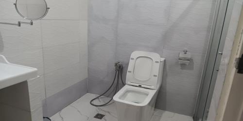 a white bathroom with a toilet and a mirror at Michael's Homestay - Farm Villa near Patar Beach & Bolinao Falls in Bolinao