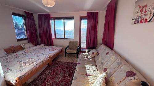 een slaapkamer met twee bedden en een stoel en ramen bij Maisonette on the slope in Manastir 3 in Pamporovo