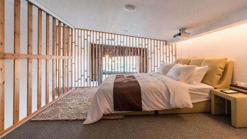 a bedroom with a bed with a wooden wall at W Jiwoo Resort in Gapyeong
