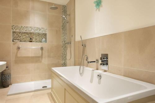 a bathroom with a tub and a shower and a sink at Glen Bank in Bampton