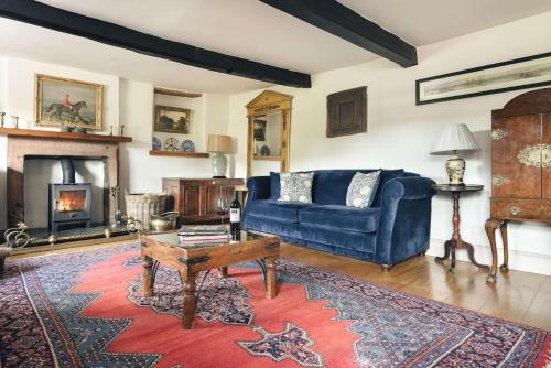 a living room with a blue couch and a fireplace at Glen Bank in Bampton