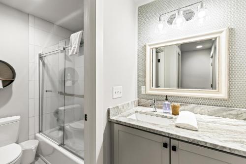 a white bathroom with a sink and a mirror at Lagoon Villa 43 - Close to Ocean! Easy Access to Resort! in Isle of Palms