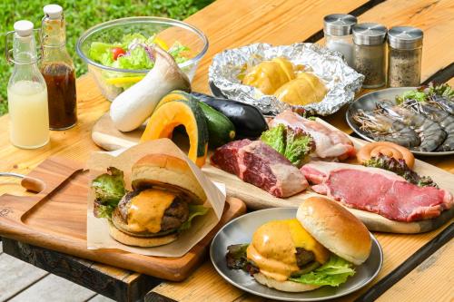 a wooden table with plates of food on it at glampark FREE AND EASY CAMP RESORT　三重県 in Komono