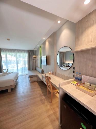 a kitchen and living room with a couch and a mirror at Baan Karon Resort in Karon Beach