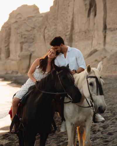 a man and a woman riding a horse on the beach at Magma Resort Santorini, In The Unbound Collection By Hyatt in Vourvoulos