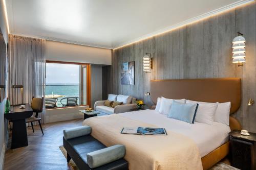 a hotel room with a bed and a living room at Carlton Tel Aviv Hotel – Luxury on the Beach in Tel Aviv