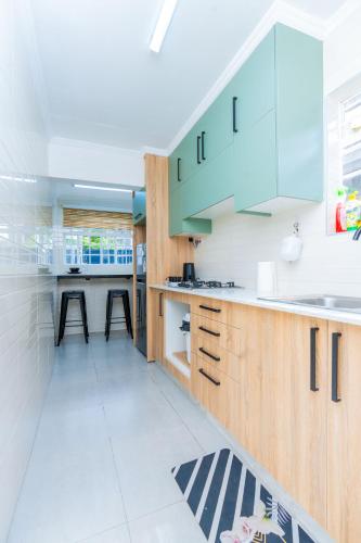 a kitchen with blue cabinets and a white floor at Perfect 2BR Airport Layover Transit Accommodation - High Speed WiFi 30mbps in Nairobi
