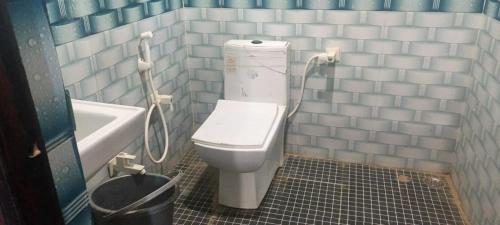 a bathroom with a toilet and a sink and a tub at Gopi Dham in Chhatikara