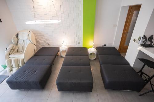 a room with four black couches in a room at Apartment PLAZA -Wallbox 11kW- Private SPA- Jacuzzi, Infrared Sauna, Luxury massage chair, Parking, Entry with PIN 0 - 24h, FREE CANCELLATION 24 hours before Check In,Premium pillows and mattress in Slavonski Brod