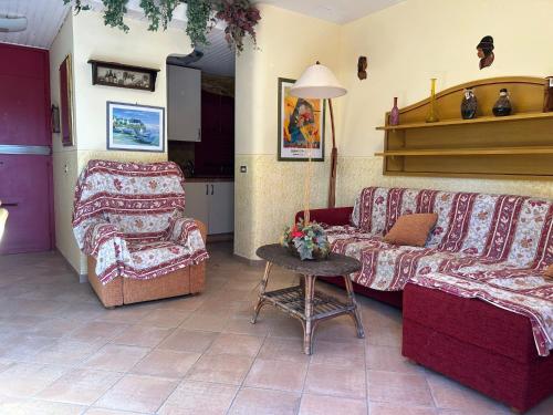 a living room with two couches and a table at Appartamento in residence con piscina in Marina di Bibbona
