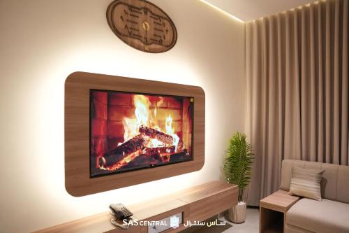 a living room with a fireplace and a clock on the wall at SAS Central in Salalah