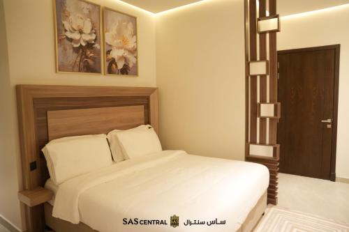 a bedroom with a bed with white sheets at SAS Central in Salalah