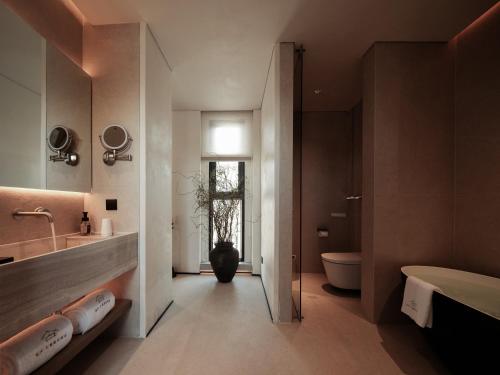a bathroom with a tub and a sink and a toilet at Da Li Yuan Lu Hotel in Dali Ancient Town