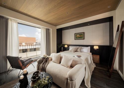 a bedroom with a bed and a couch and a window at Da Li Yuan Lu Hotel in Dali Ancient Town
