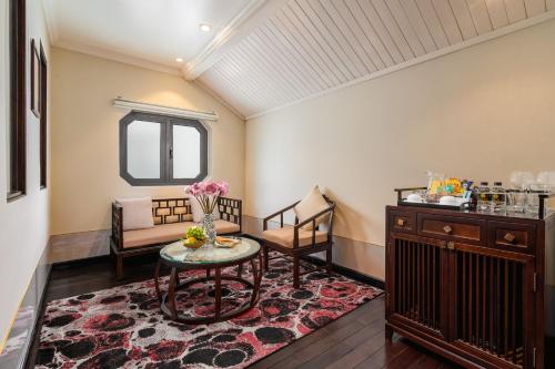 a room with a table and chairs and a window at Laluna Hoi An Riverside Hotel & Spa in Hoi An
