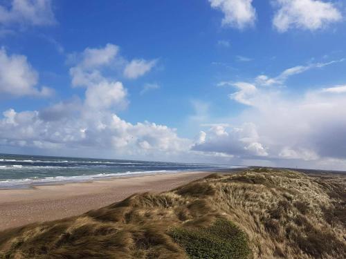 a sandy beach with the ocean in the background at 6 person holiday home in Brovst in Brovst