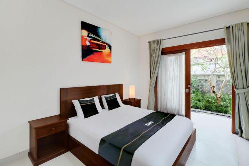 ein Schlafzimmer mit großem Bett und Fenster in der Unterkunft Collection O Bali Sanur near Bali Mandara Hospital in Sanur