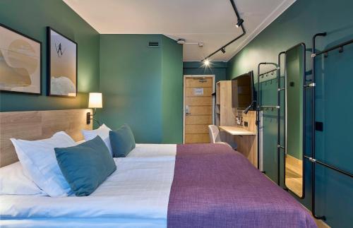 a bedroom with a bed with blue and green walls at Scandic Lugnet in Falun