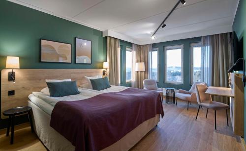 a hotel room with a bed and a desk at Scandic Lugnet in Falun