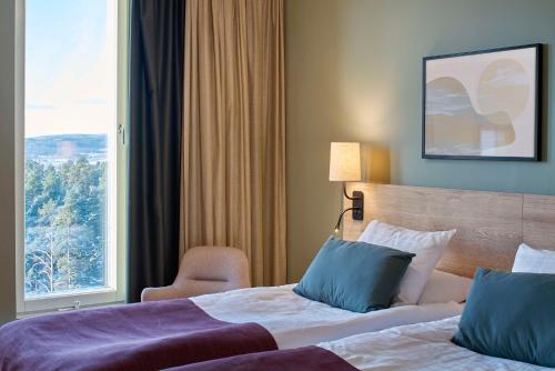 a hotel room with two beds and a window at Scandic Lugnet in Falun