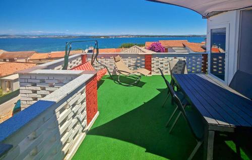 a balcony with a green yard with a bench at Awesome Apartment In Tkon With House Sea View in Tkon