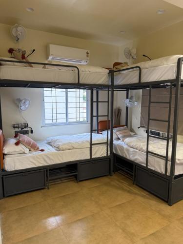 twee stapelbedden in een kamer met een raam bij OffDuty Hostel Koregaon Park in Pune