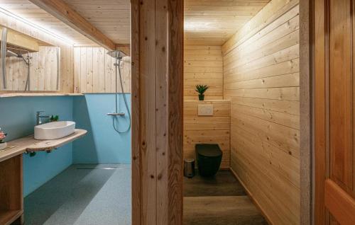 a bathroom with wooden walls and a sink and a shower at Privates Chalet Mit Pool in Stainz