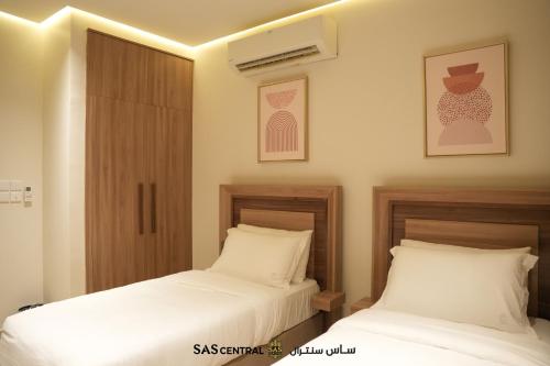 two beds sitting next to each other in a bedroom at SAS Central in Salalah