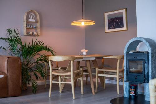 a dining room with a table and chairs and a stove at Delicate apartment with magical views in Tromsø