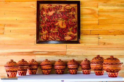 a group of vases on a shelf in front of a painting at KAYJAY WILD WILPATTU in Wilpattu