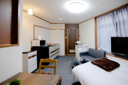 Habitación pequeña con cama y mesa en Fushimi Railway House, en Kioto