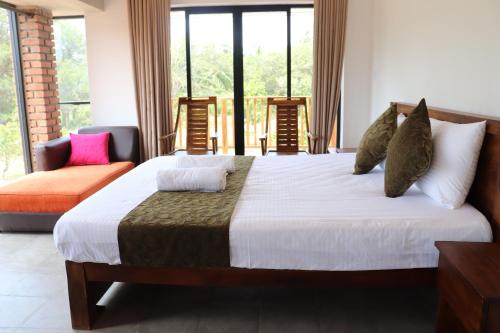 a bedroom with a large bed and a large window at KAYJAY WILD WILPATTU in Wilpattu