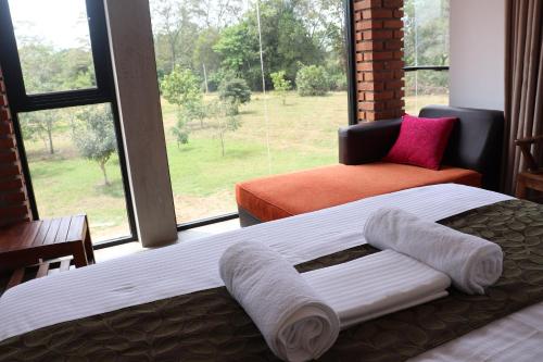 a bedroom with two beds and a large window at KAYJAY WILD WILPATTU in Wilpattu