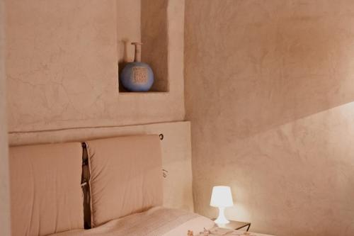 a bedroom with a bed and a blue vase on the wall at Pinkhouse in Mercatale