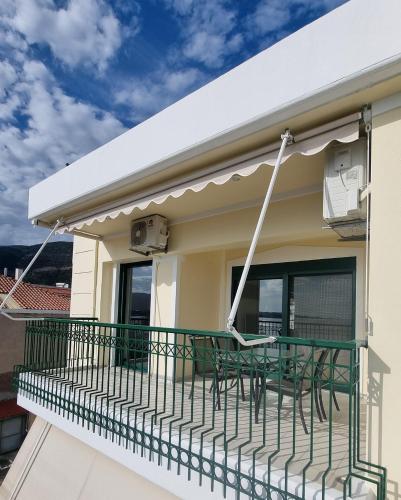 a balcony with chairs and an awning on a house at Place 2 Be in Nafpaktos