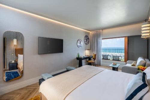 a hotel room with a large bed and a large window at Carlton Tel Aviv Hotel – Luxury on the Beach in Tel Aviv